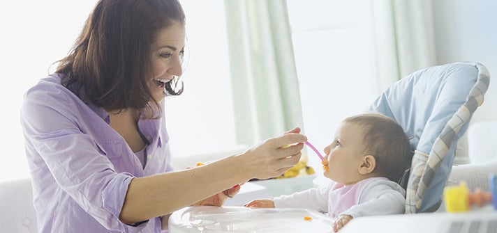 baby being fed pureed food by caregiver