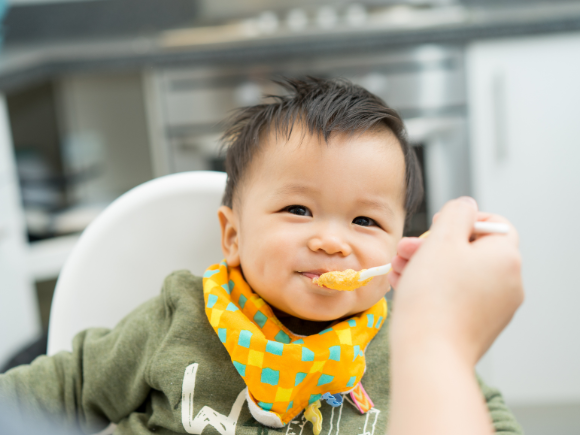toddler eating from spoon from parent 