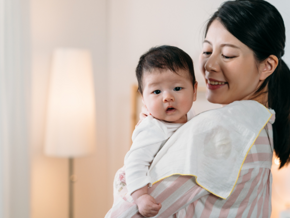 mother holding her baby with towel on her shoulder