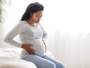 Woman in labour holding her pregnant belly