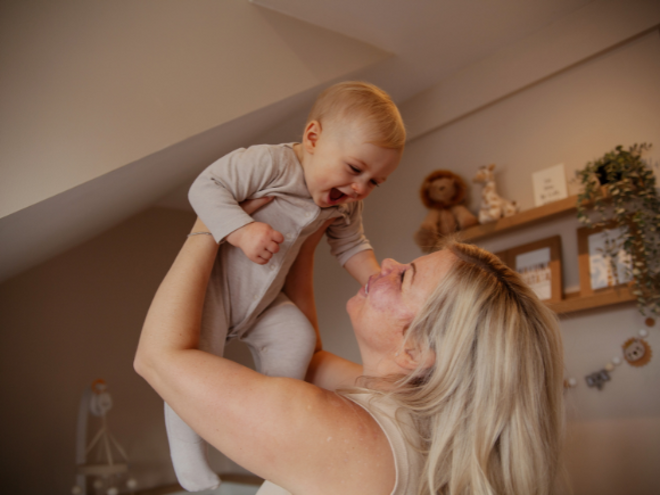 Mother holding baby in the air 