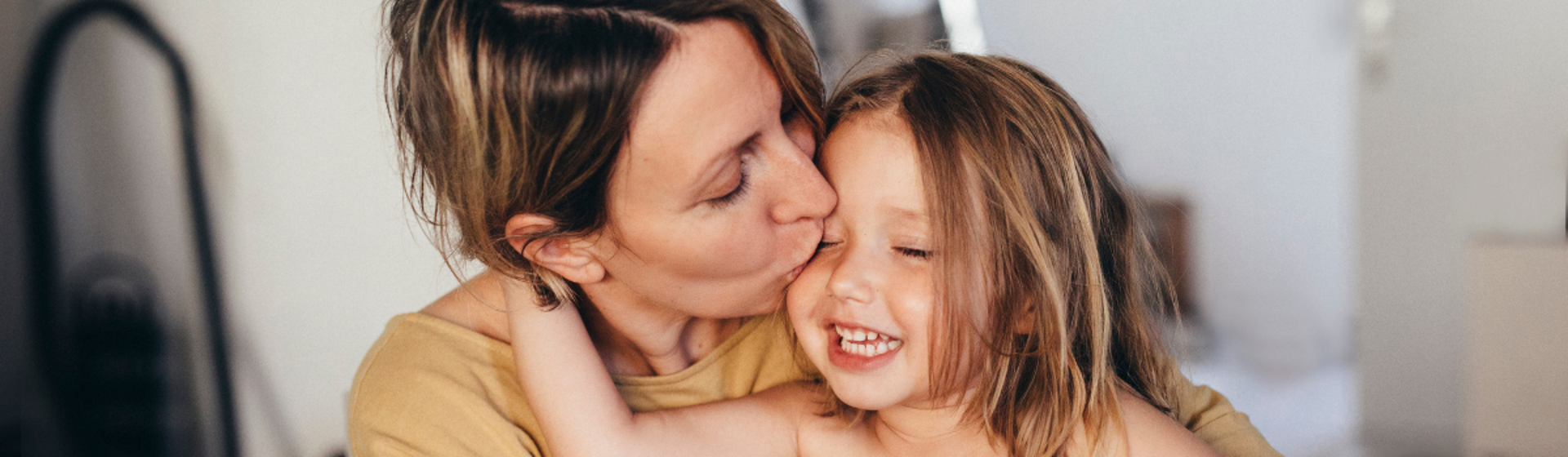 Mother kissing her daughter