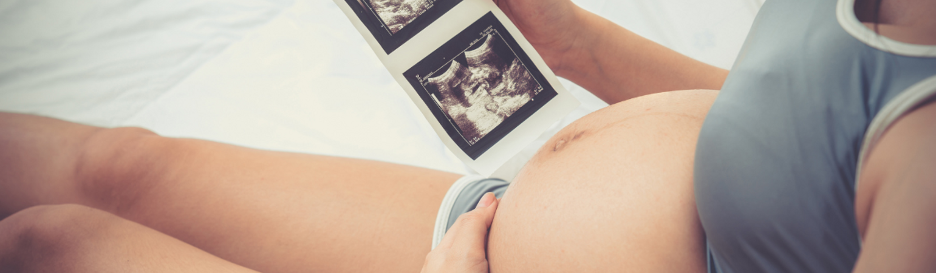 Pregnant woman holding a baby scan image